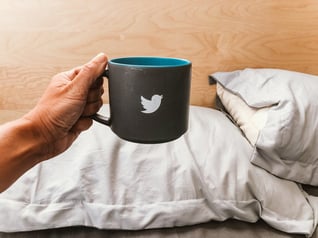 hand-holding-mug-with-a-tweeter-bird-sign-2022-11-15-02-18-26-utc (1)